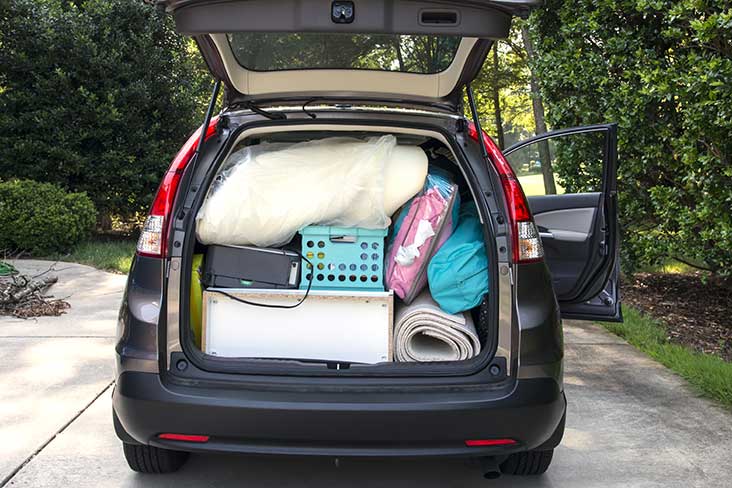 the trunk of a car full of blankets and bins